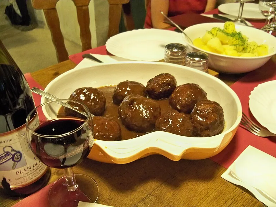 Boulets à la liégeoise in dunkler Sauce auf einem Restauranttisch
